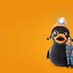 Ein kleines Kind steht neben einem großen Cartoon-Pinguin, der einen Helm mit einer Stirnlampe trägt, vor einem leuchtend orangefarbenen Hintergrund.