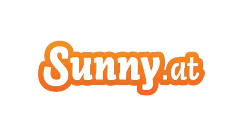 „Sunny.at“-Logo in Orange mit weißem Umriss auf weißem Hintergrund.