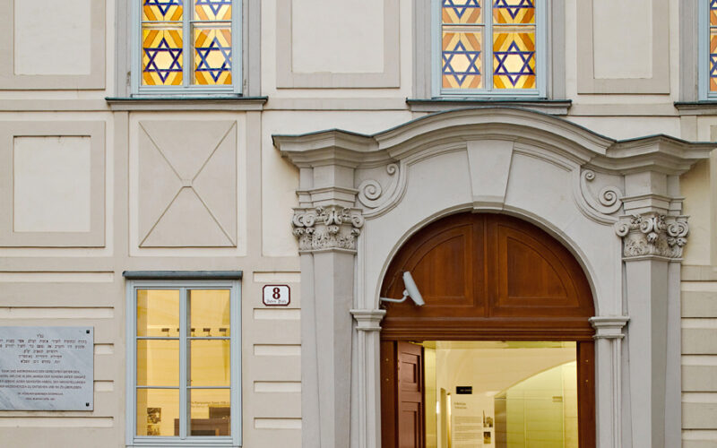 Der Eingang zum Museum Judenplatz mit seinem Rundbogenportal, der Steinfassade und den Glasfenstern mit Davidstern.