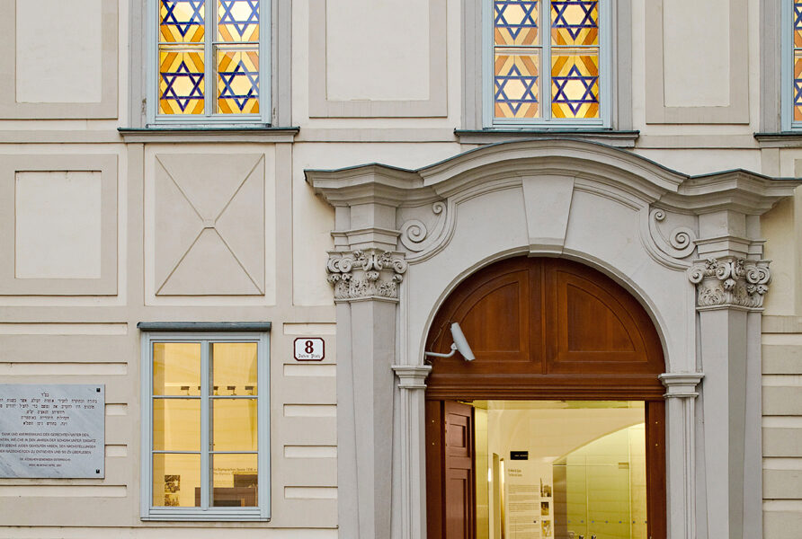Der Eingang zum Museum Judenplatz mit seinem Rundbogenportal, der Steinfassade und den Glasfenstern mit Davidstern.