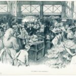 Eine belebte Szene in einem Innenraum zeigt Menschen, die sich um einen Mann an einem Tisch versammelt haben, der Dokumente unterschreibt, während überall im Raum Topfpflanzen und Blumen aufgestellt sind.