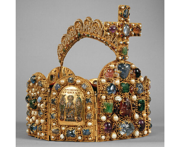 Eine mit Edelsteinen, Perlen und einem großen Kreuz geschmückte Goldkrone, die in der Mitte mit einem Bild und Inschriften verziert ist.