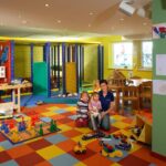 Eine Frau und zwei Kinder in einem Spielzimmer.