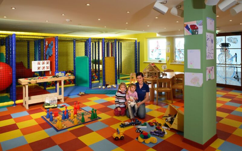 Eine Frau und zwei Kinder in einem Spielzimmer.