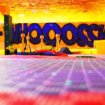 Bunter Indoor-Spielbereich mit Schwerpunkt auf Spielzeug-Hindernisparcours-Elementen, Graffiti-Stil "WHOOOSH" an der Wand und verstreuten grünen Lichtern auf dem Boden.