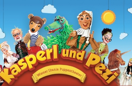 Über dem Text „Kasperl und Pezi“ sind vor einem blauen Himmel mit Wolken und einer Sonne bunte Puppen abgebildet, darunter ein Bär, ein Krokodil und menschliche Figuren.