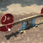 Eine rote und braune gefederte Wippe mit tierförmigen Enden auf einem Spielplatz mit Holzspänen und Beton.