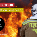 Ein Feuerwehrmann in voller Montur steht vor großen Flammen; ein deutscher Text wirbt für eine Feuerwehr-Tour namens "Faszination Feuerwehr" mit Buchungsinformationen.