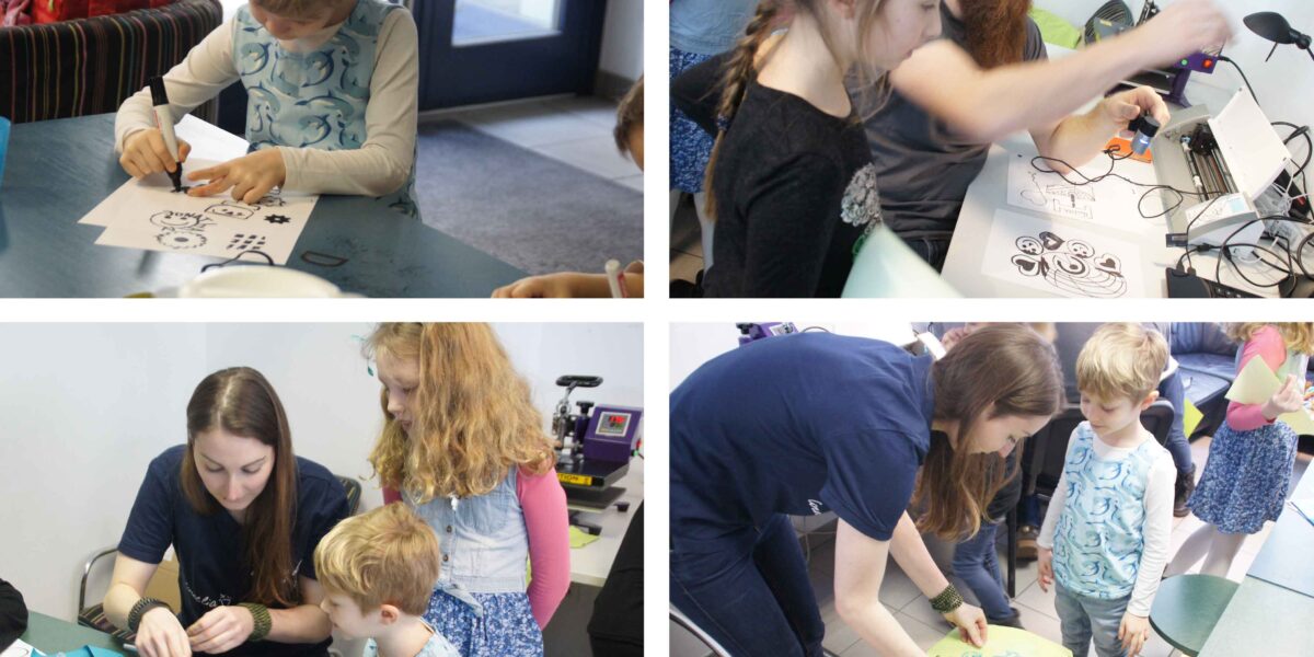 Kinder und Erwachsene arbeiten gemeinsam an Bastelprojekten an Tischen, mit Papier, Markern und anderen Materialien in einem Klassenzimmer.