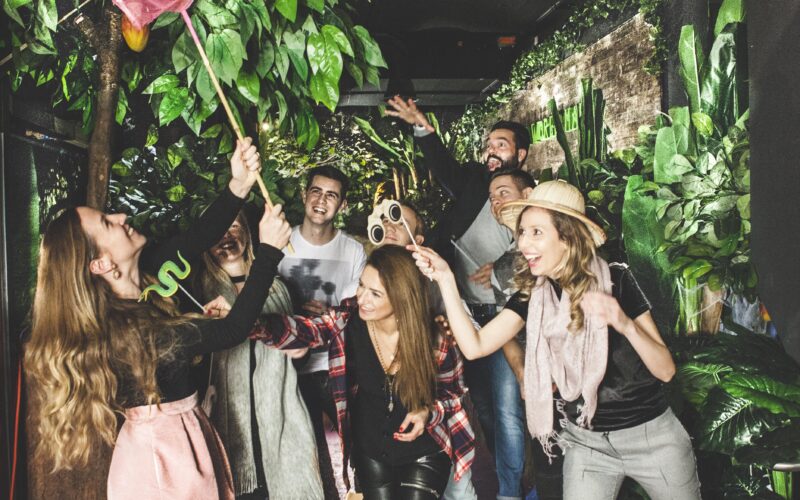 Eine Gruppe von Menschen posiert spielerisch unter einem „JUNGLE“-Schild im Schokoladenmuseum Wien, umgeben von künstlichen Pflanzen und Dekorationen zum Thema Dschungel.