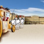 Eine Zeichentrickfigur fährt in einer gelben Kutsche, die von weißen Pferden gezogen wird, vor einem großen Palastgebäude.