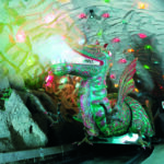 Ein großer animatronischer Drache mit leuchtenden Augen und Maul sitzt in einem Höhlentunnel, der mit bunten Lichtern dekoriert ist.