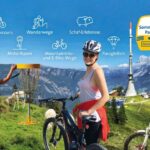 Die Menschen genießen verschiedene Outdoor-Aktivitäten wie Radfahren, Wandern, Disc-Golf und den Umgang mit Schafen in einer bergigen Landschaft unter sonnigem Himmel. Aktivitätsschilder und ein Zeitplan sind sichtbar.