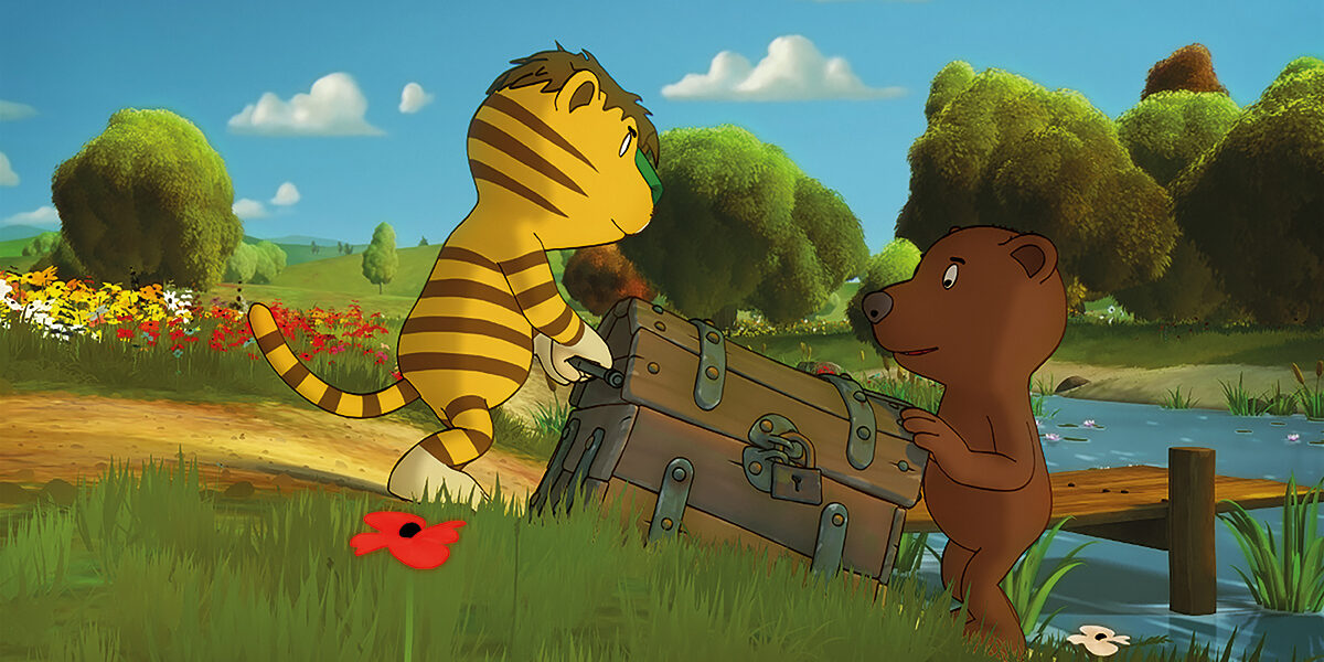 Ein animierter Tiger und ein Bär tragen eine große Truhe neben einem Bach in einer grasbewachsenen, blumenreichen Landschaft mit Bäumen im Hintergrund.