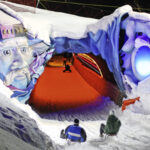 Zwei Personen auf Schlitten nähern sich einem Schneetunnel, der nachts mit einem bunten Gesicht und leuchtenden Lichtern geschmückt ist.