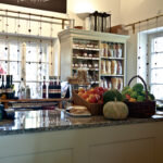 Ein Lebensmittelladen mit einer Auslage mit frischen Produkten, Backwaren, Weinflaschen und Regalen mit Nudeln und verpackten Waren im Hintergrund.