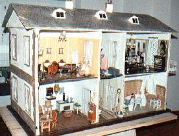 Ein zweistöckiges Puppenhaus mit detaillierten Miniaturmöbeln und -dekorationen, das verschiedene Räume wie Küche, Wohnbereich und Schlafzimmer zeigt.