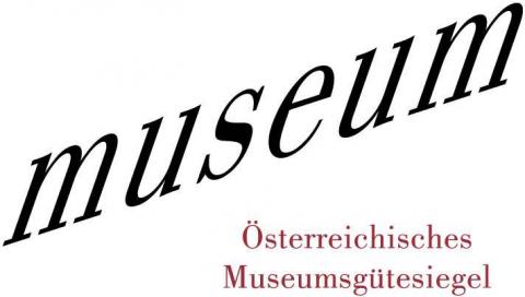 Das Wort "Museum" erscheint in großer, kursiver schwarzer Schrift; darunter steht in kleinerer roter Schrift "Österreichisches Museumsgütesiegel".