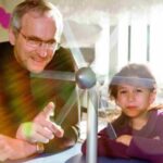 Ein Mann und ein Mädchen schauen auf eine Windmühle.