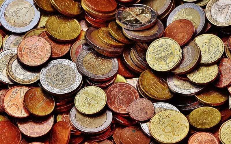 Ein Stapel verschiedener Euro-Münzen mit unterschiedlichen Nennwerten und Farben, die übereinander liegen.