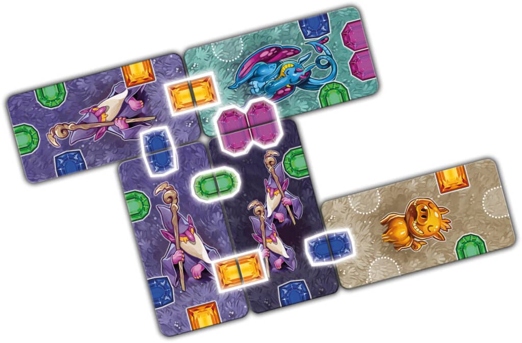 Vier illustrierte Spielkarten mit farbenfrohen Edelsteinen und Fantasiewesen, die sich an den Orten der leuchtenden Edelsteine überlappen, liegen versetzt auf einem weißen Hintergrund.