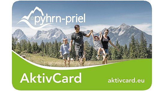 Eine vierköpfige Familie wandert auf einem Weg mit Bergen im Hintergrund; auf der Karte stehen "pyhrn-priel", "AktivCard" und "aktivcard.eu".