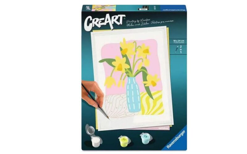 CreArt Malen nach Zahlen Kit zeigt eine Hand malen gelbe Blumen in einer blauen Vase mit einem rosa Hintergrund; drei kleine Farbtöpfe und ein Pinsel sind enthalten.