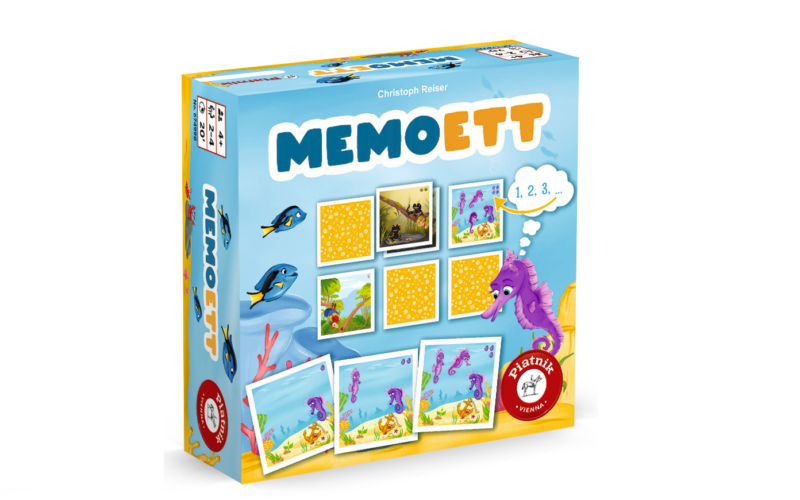 Eine farbenfrohe Brettspielschachtel mit dem Titel "Memoett", die Bilder von Fischen, Meerestieren und Karten zeigt, mit einer Seepferdchen-Illustration und einem roten Preissiegel auf der Vorderseite.
