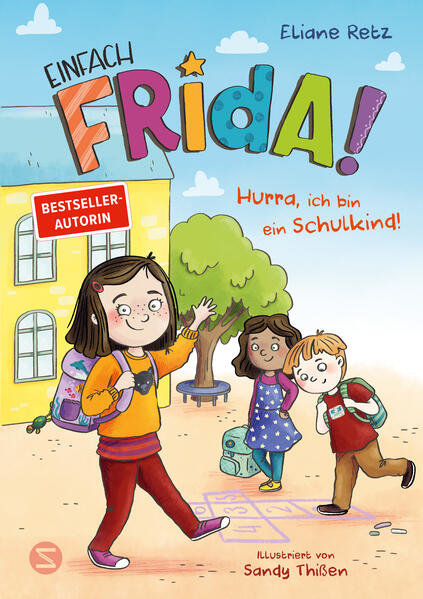 Der illustrierte Bucheinband zeigt ein lächelndes Mädchen mit einem Rucksack, das vor einer Schule winkt, mit zwei anderen Kindern in der Nähe. Der Titel lautet "Einfach Frida! Hurra, ich bin ein Schulkind!.