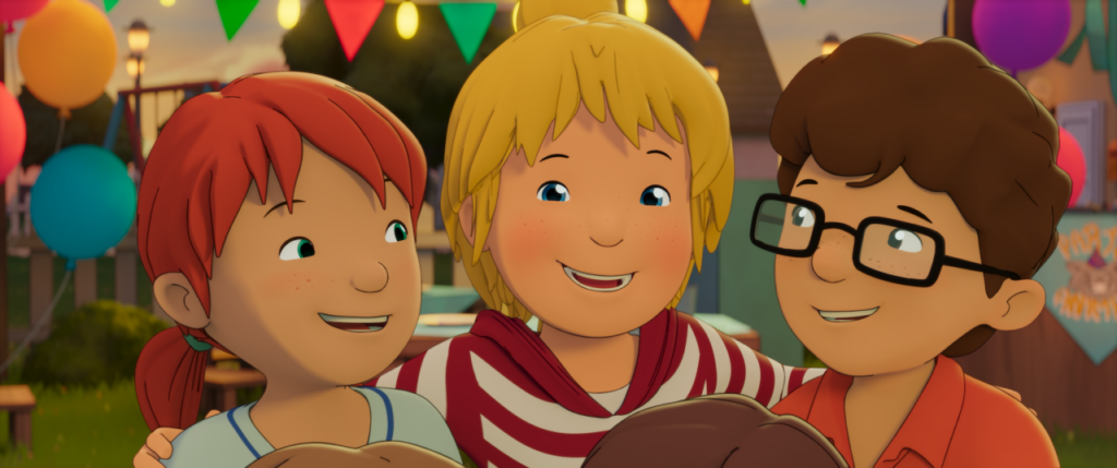 Drei lebhafte Kinder, zwei mit roten und blonden Haaren und eines mit braunen Haaren und Brille, lächeln zusammen auf einer Party im Freien mit Luftballons und bunten Fahnen im Hintergrund.