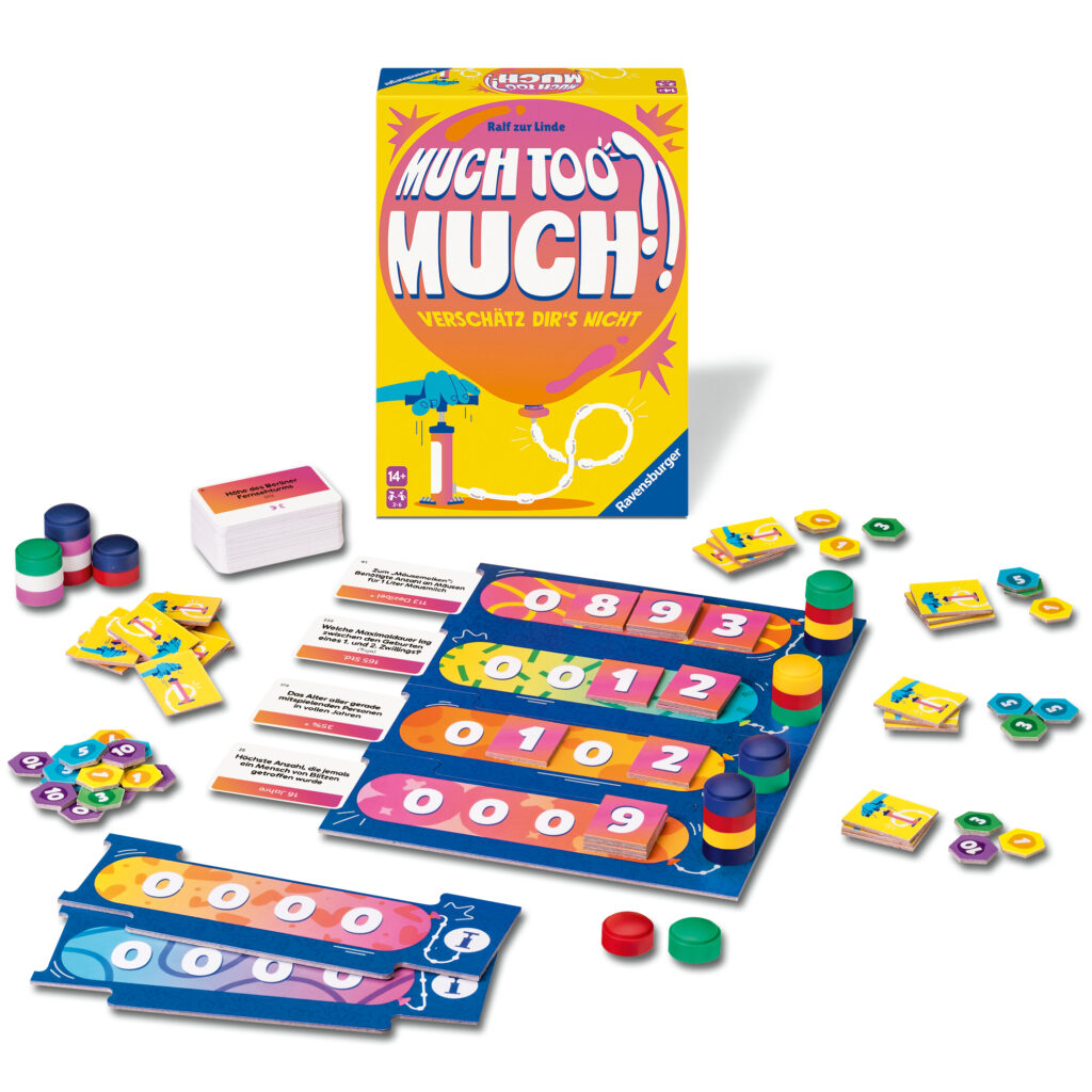 Ein Brettspiel namens "Much Too Much!" mit bunten Spielbrettern, Karten, Spielsteinen und Kacheln, die um die geöffnete Schachtel herum angeordnet sind.