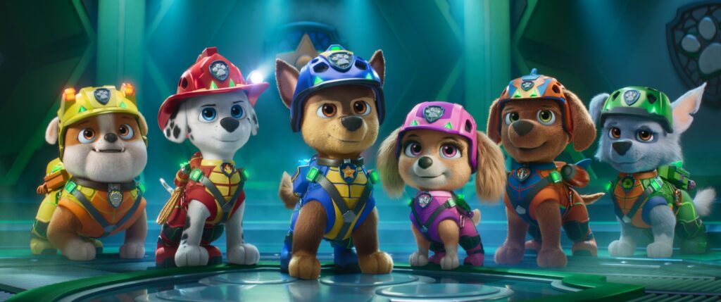Sechs animierte Hunde in bunten Uniformen und Helmen stehen in einem futuristischen Raum und blicken nach vorne.