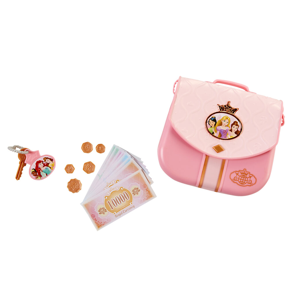 Rosa Spielzeughandtasche mit Prinzessinnenmotiv, Spielgeld, Münzen, einem Schlüssel und einem Schlüsselanhänger, angeordnet auf weißem Hintergrund.