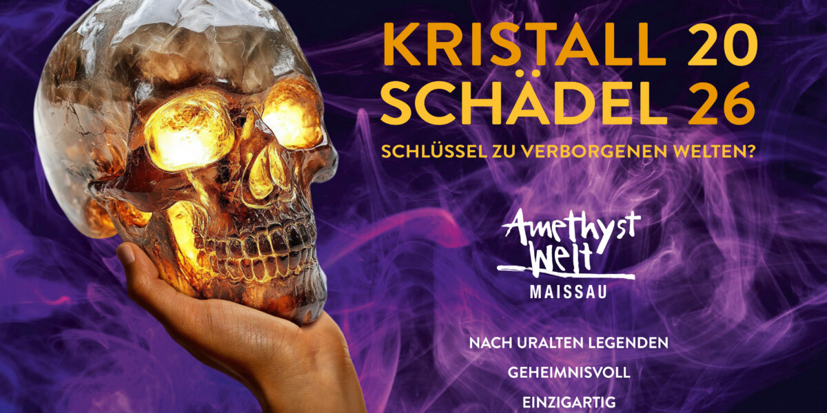 Eine Hand hält einen durchsichtigen Kristallschädel vor einem rauchig-violetten Hintergrund, dazu ist ein deutscher Text zu sehen, der für eine Ausstellung in der „Amethyst Welt Maissau“ wirbt.