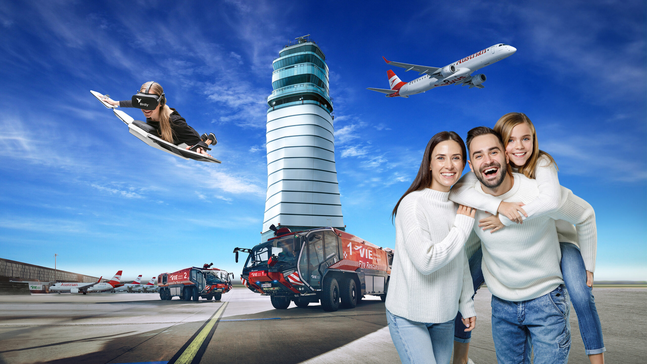 Ein Paar posiert auf einem Flughafen vor einem Kontrollturm, Feuerwehrautos, Flugzeugen und einer Person, die auf einem Jet-Surfbrett am Himmel schwebt.